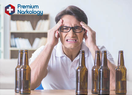 Профилатика алкогольной амнезии Мужчина сидит перед пустыми бутылками